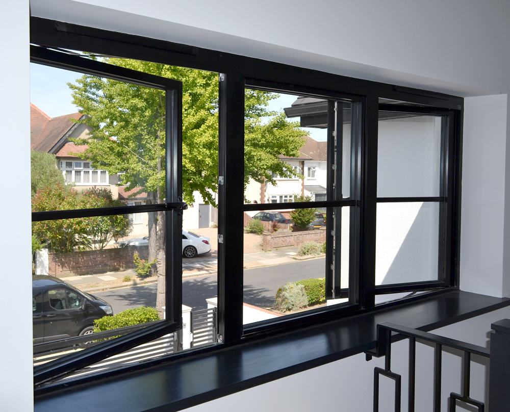 black aluminium casement windows looking out to the road from inside the house