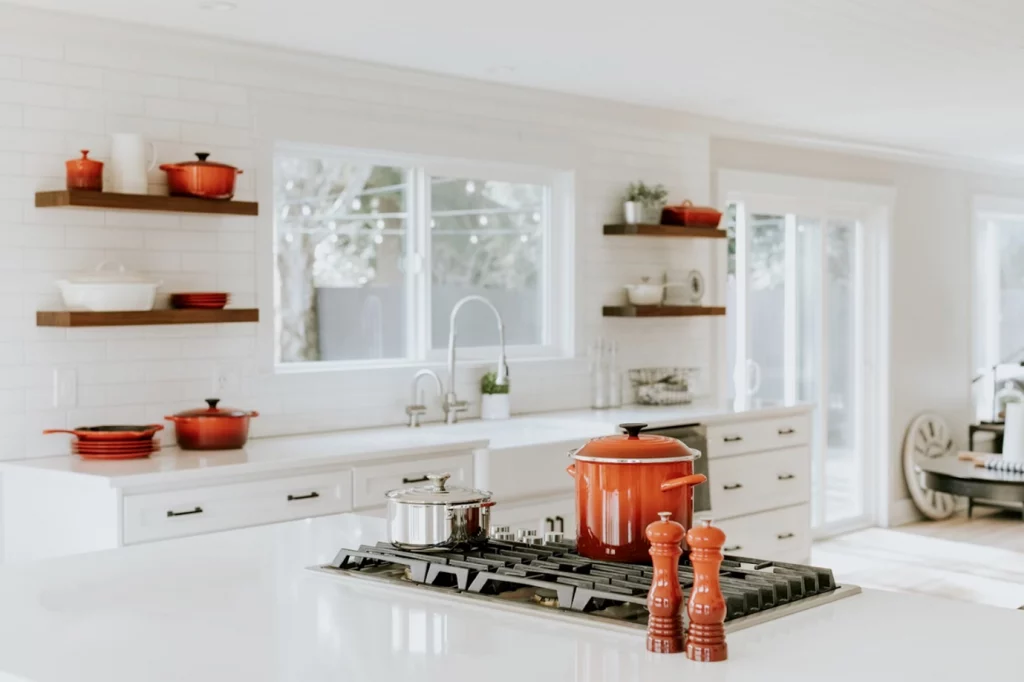 White kitchen with orange pots and pans