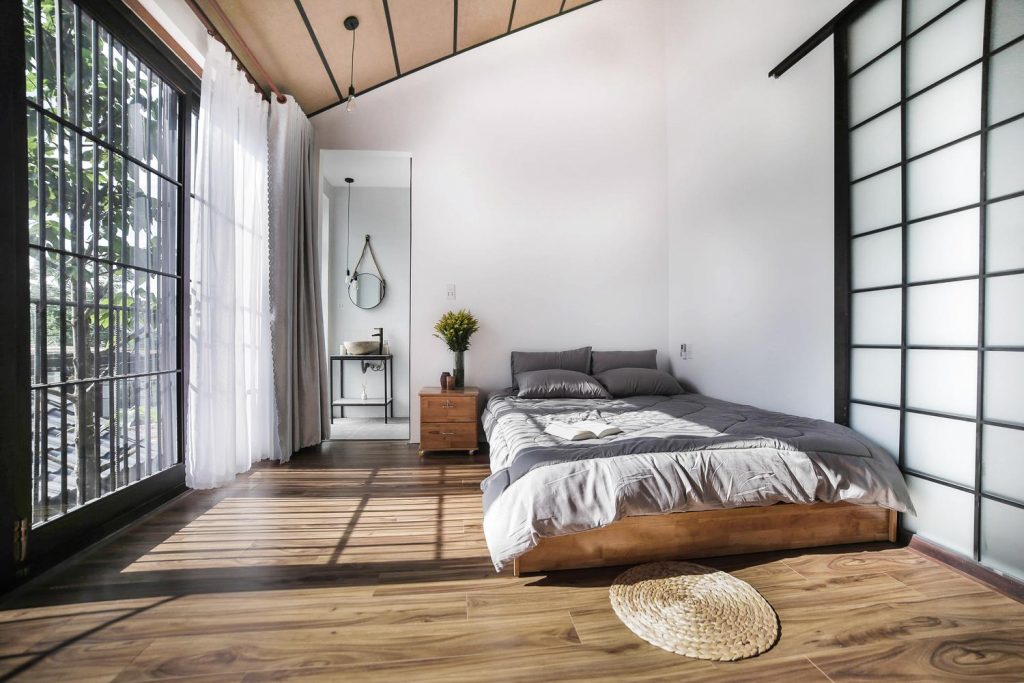 Japanese style bedroom.  Bed on the floor with minimalist design. Wood floors and roof. 